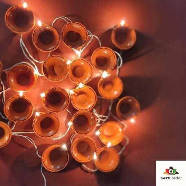 A Diya Light Toran featuring a traditional garland design adorned with glowing diya-shaped lights. The toran is beautifully crafted to hang over doorways or windows, emitting a soft, warm glow. Perfect for Diwali or festive occasions, it adds an elegant and welcoming touch to any home decor, both indoors and outdoors.