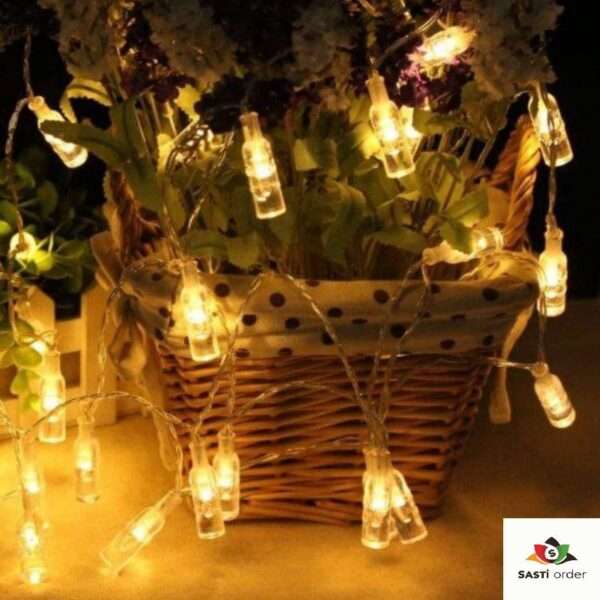 A string of 10 LED Bottle Shape Lights featuring mini bottle-shaped bulbs emitting a warm glow. The unique design adds a playful and stylish touch to any decor, ideal for indoor or outdoor use at parties, weddings, or home decorations. Battery-powered for easy portability and versatile placement.